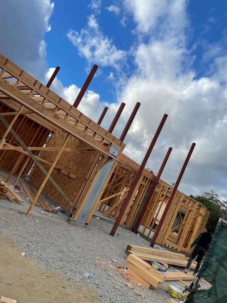 Framing in progress with metal poles supporting the structure.
