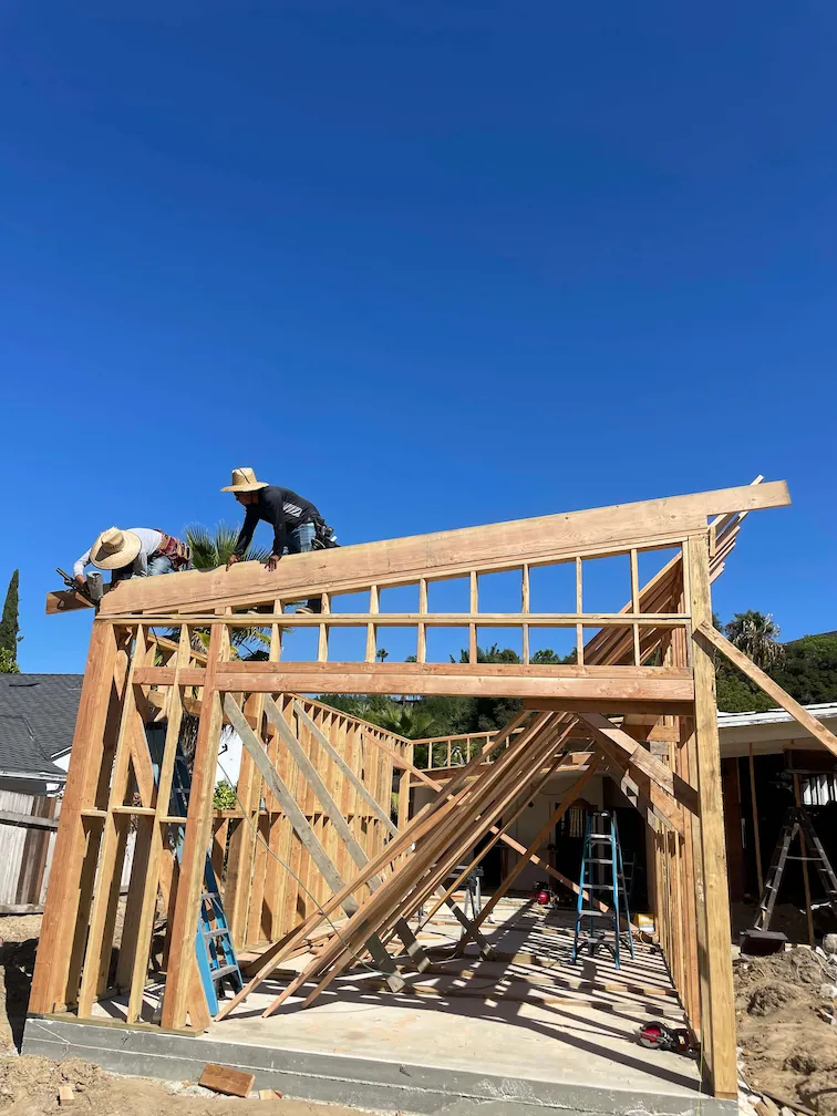 Construction workers building the framing of a house after completing the foundation.